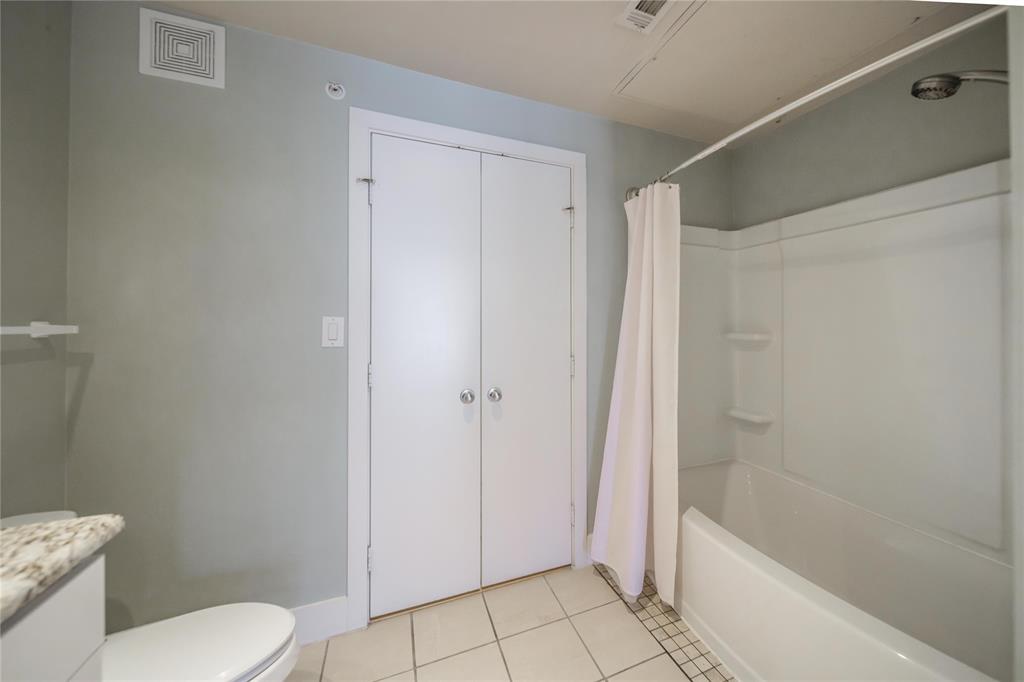 4414 Cedar Springs Road, Unit 214 Dallas, TX 75219 - Photo 19 of 29 Bathroom with light tile patterned flooring, vanity, and shower / bath combination with curtain