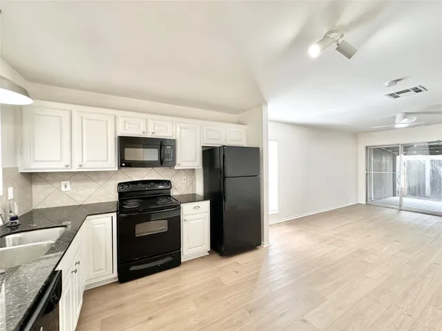 a kitchen with stainless steel appliances granite countertop a stove a refrigerator and a sink