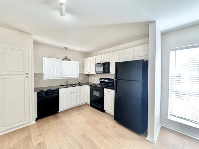 a kitchen with a refrigerator stove top oven and sink
