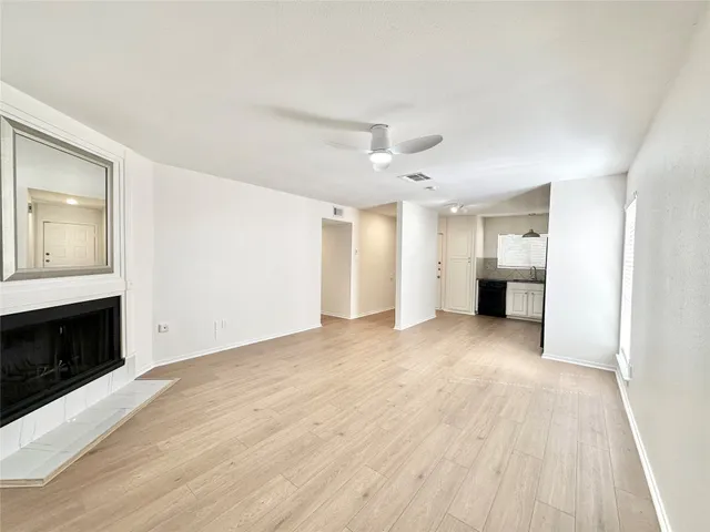 a view of a big room with wooden floor and a kitchen