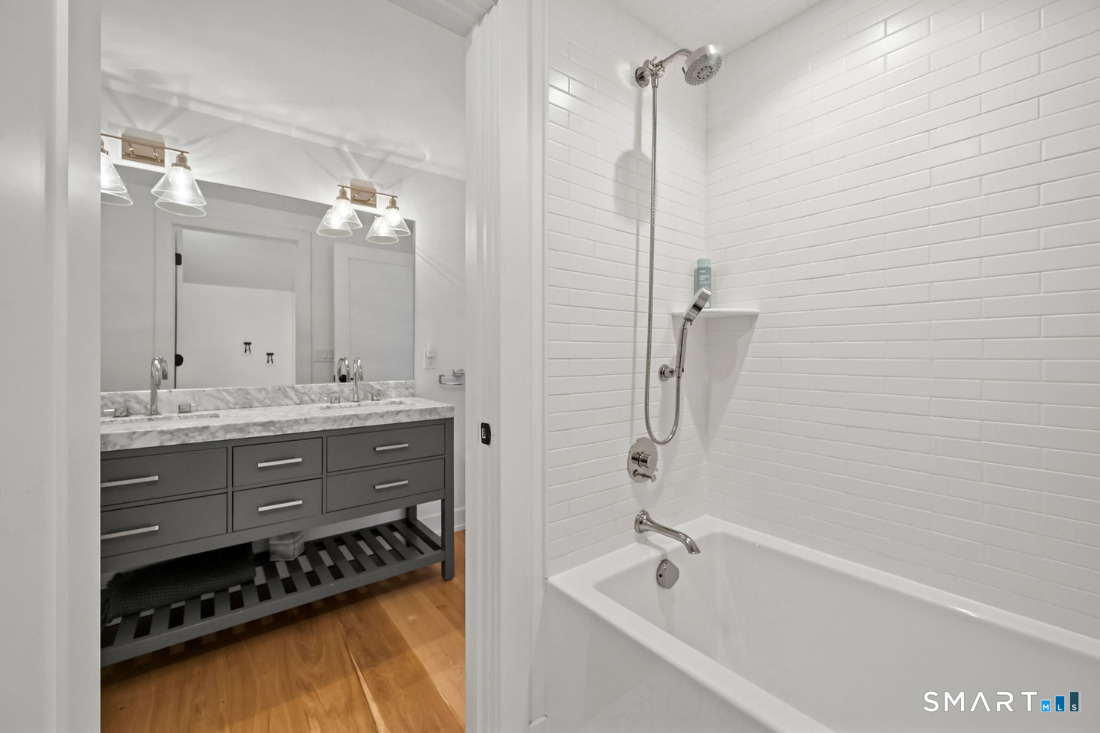 187 Catherine Terrace Fairfield, CT 06824 - Photo 30 of 40 Full bath in hall includes a privacy door to tub/shower and commode with tiled floors. The handsome double vanity is offset by hardwood floors.