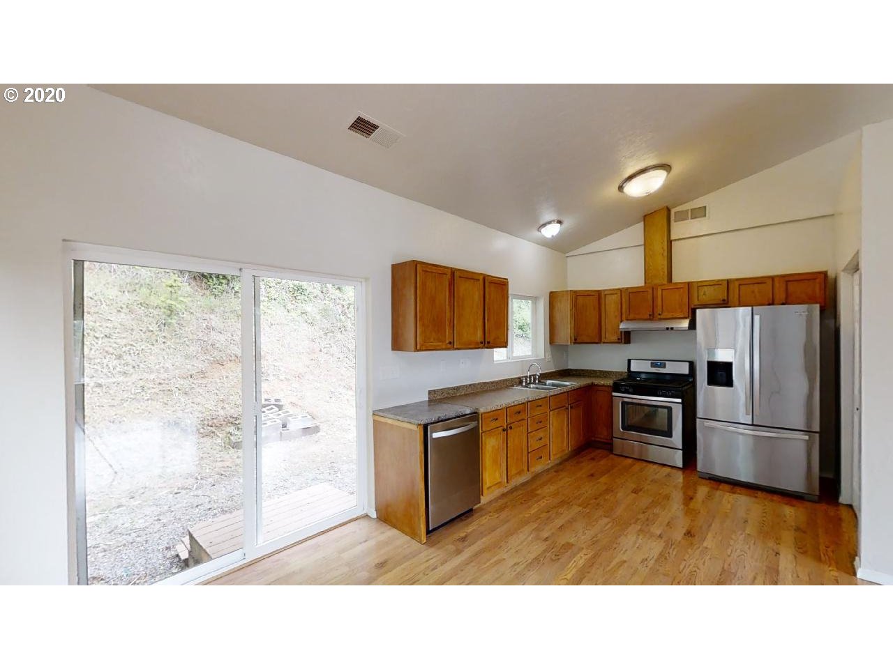 340 Kalapuya Way Cottage Grove, OR 97424 - Photo 7 of 20 a kitchen with stainless steel appliances granite countertop a refrigerator a sink a stove and a wooden floors