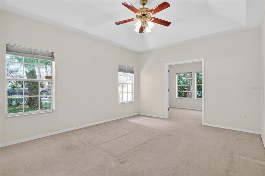 9626 Southwest 53rd Road Gainesville, FL 32608 - Photo 13 of 23 an empty room with chandelier fan and windows