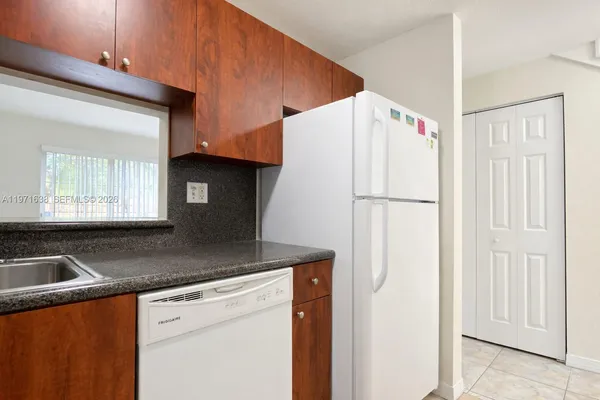 a kitchen with a sink a refrigerator and cabinets