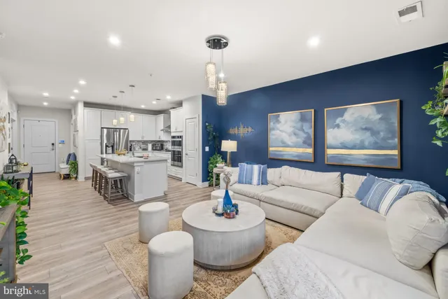a living room with furniture and a dining table with kitchen view