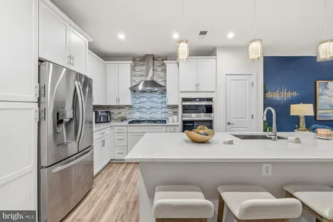 a kitchen with stainless steel appliances kitchen island granite countertop a sink and refrigerator