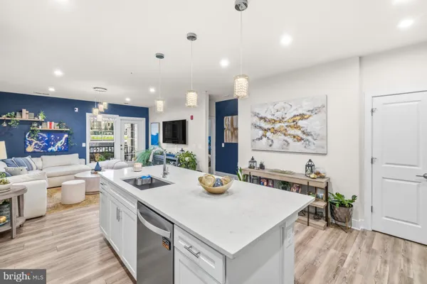 a kitchen that has a lot of cabinets a sink and wooden floor