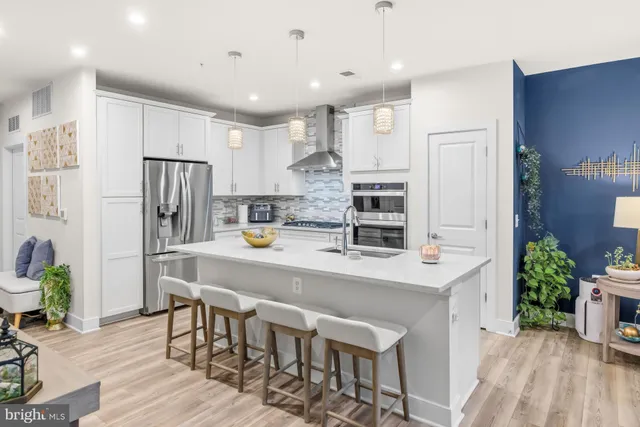 a large kitchen with kitchen island a large refrigerator a stove a dining table and chairs