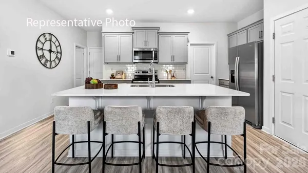 a kitchen with stainless steel appliances a table chairs and a refrigerator