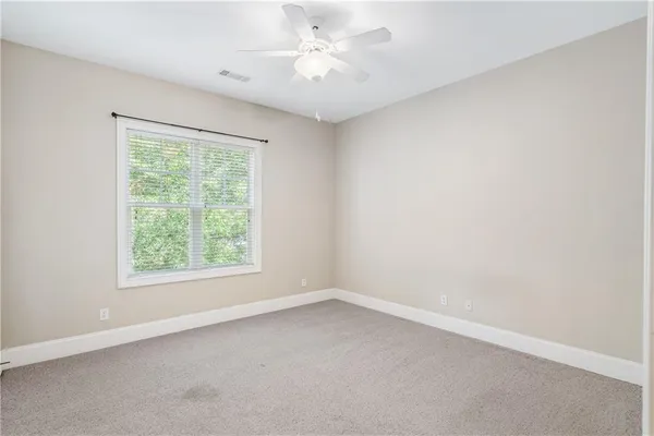 an empty room with a window and a fan