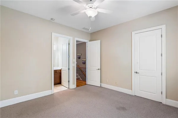 an empty room with closet and a ceiling fan