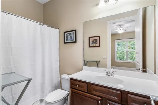 a bathroom with a granite countertop sink toilet and mirror