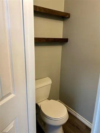 a white toilet sitting next to a shower