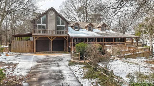 a view of an empty room with wooden floor fireplace and a window