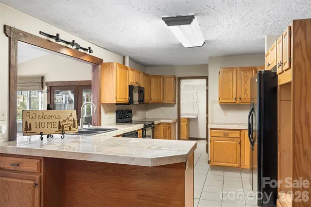 a large kitchen with stainless steel appliances granite countertop a refrigerator and a sink