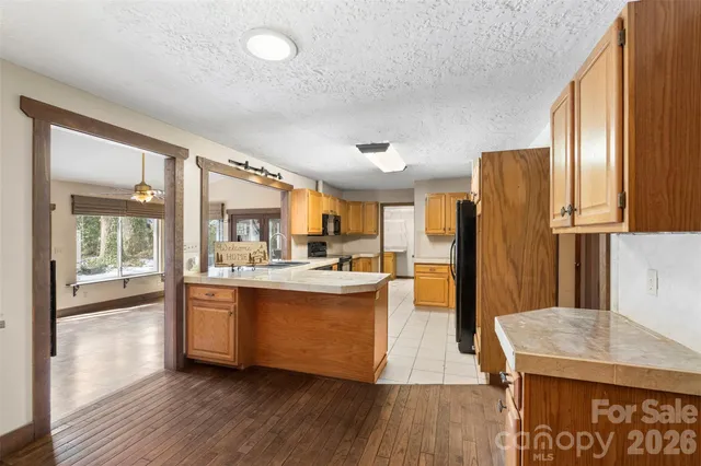 a large kitchen with stainless steel appliances granite countertop a sink and a refrigerator