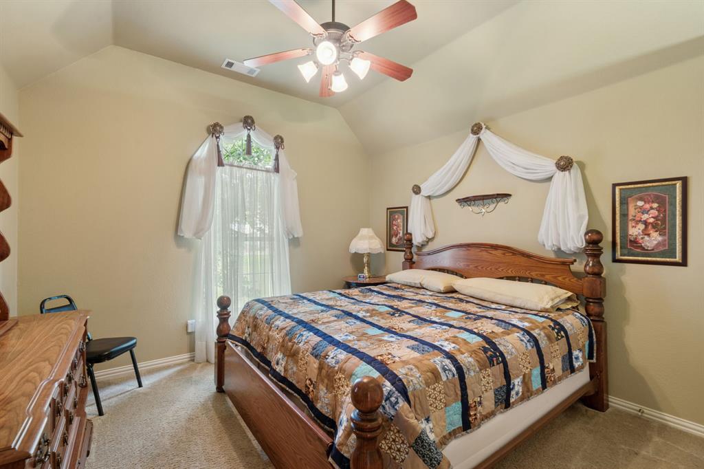 2308 Kella Court Haslet, TX 76052 - Photo 25 of 40 a bedroom with a bed and a chandelier