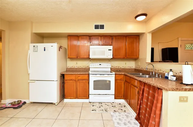 a kitchen with stainless steel appliances granite countertop a refrigerator sink stove and microwave