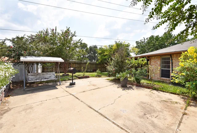 a backyard of a house with small garden and outdoor seating