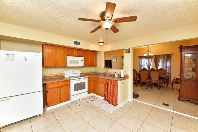 a kitchen with sink a refrigerator and chairs