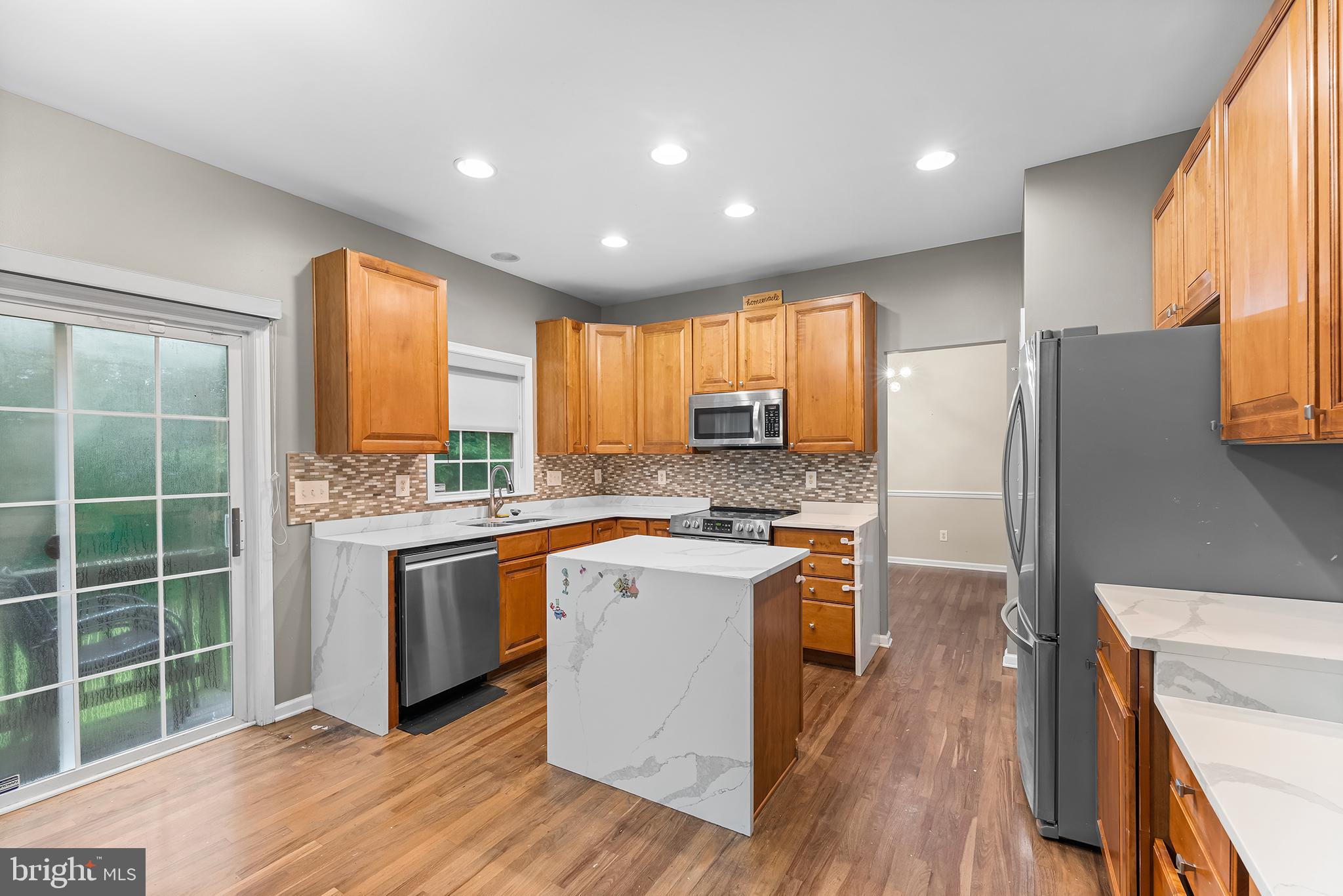 104 Constitution Terrace Elkton, MD 21921 - Photo 6 of 20 a kitchen with stainless steel appliances granite countertop a refrigerator a sink dishwasher a stove and white countertops with wooden floor