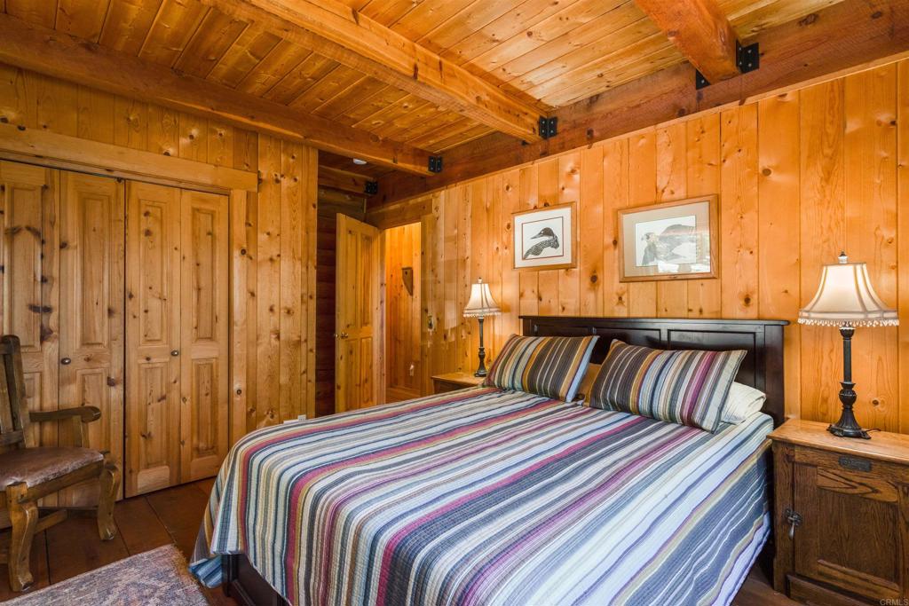 33480 Bailey Meadow Road Palomar Mountain, CA 92060 - Photo 22 of 51 a bedroom with a large bed and a chandelier