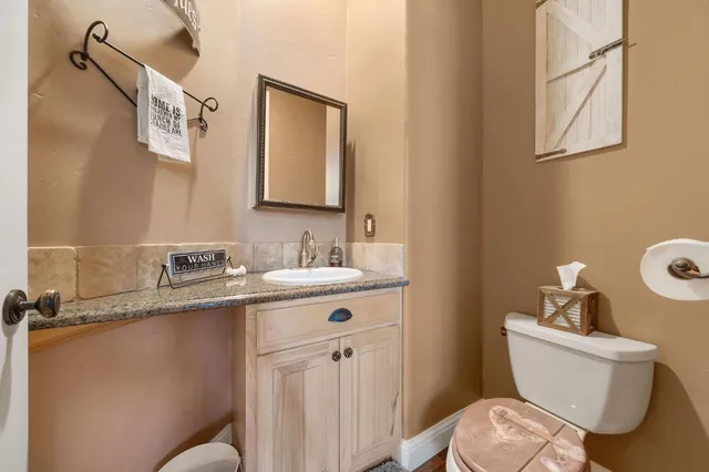 a bathroom with a granite countertop sink a mirror and shower