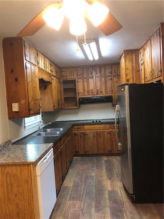 1048 Mantissa Street Northwest Atlanta, GA 30318 - Photo 4 of 12 a kitchen with stainless steel appliances granite countertop a stove a refrigerator a sink and dishwasher with wooden floor