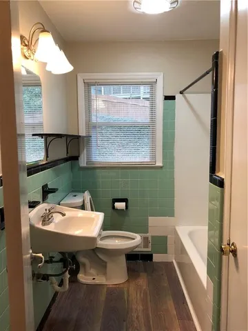 a bathroom with a sink a toilet and a mirror