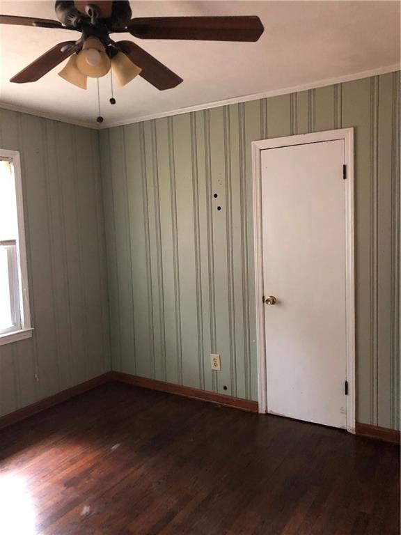 1048 Mantissa Street Northwest Atlanta, GA 30318 - Photo 7 of 12 an empty room with wooden floor closet fan and windows