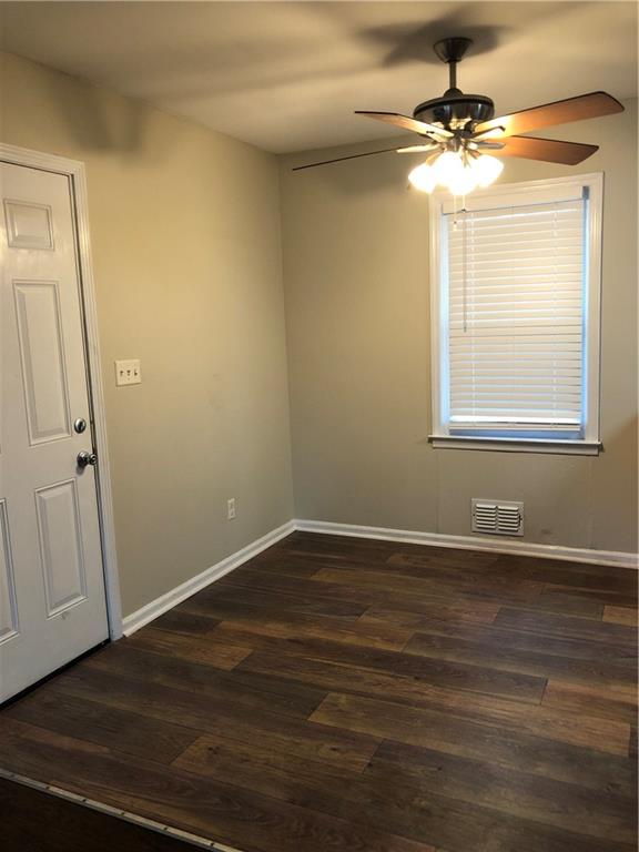 1048 Mantissa Street Northwest Atlanta, GA 30318 - Photo 8 of 12 a view of an empty room with wooden floor and a window
