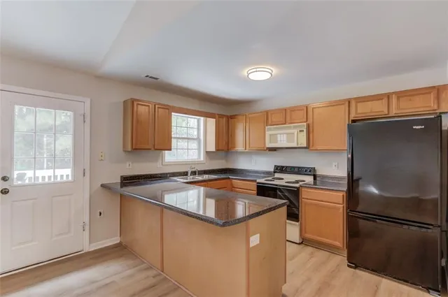 a kitchen with a sink stove top oven and cabinets