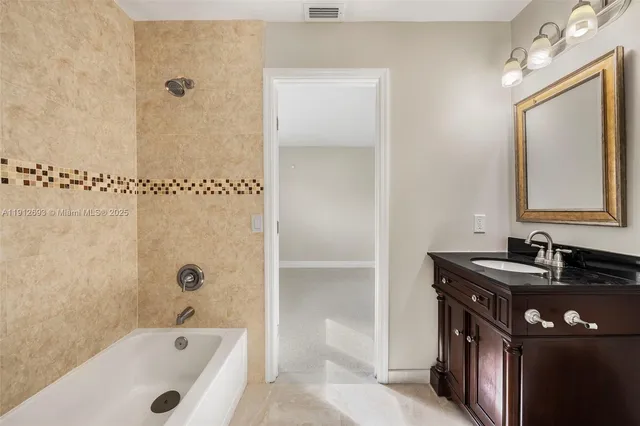 a bathroom with a tub sink and mirror