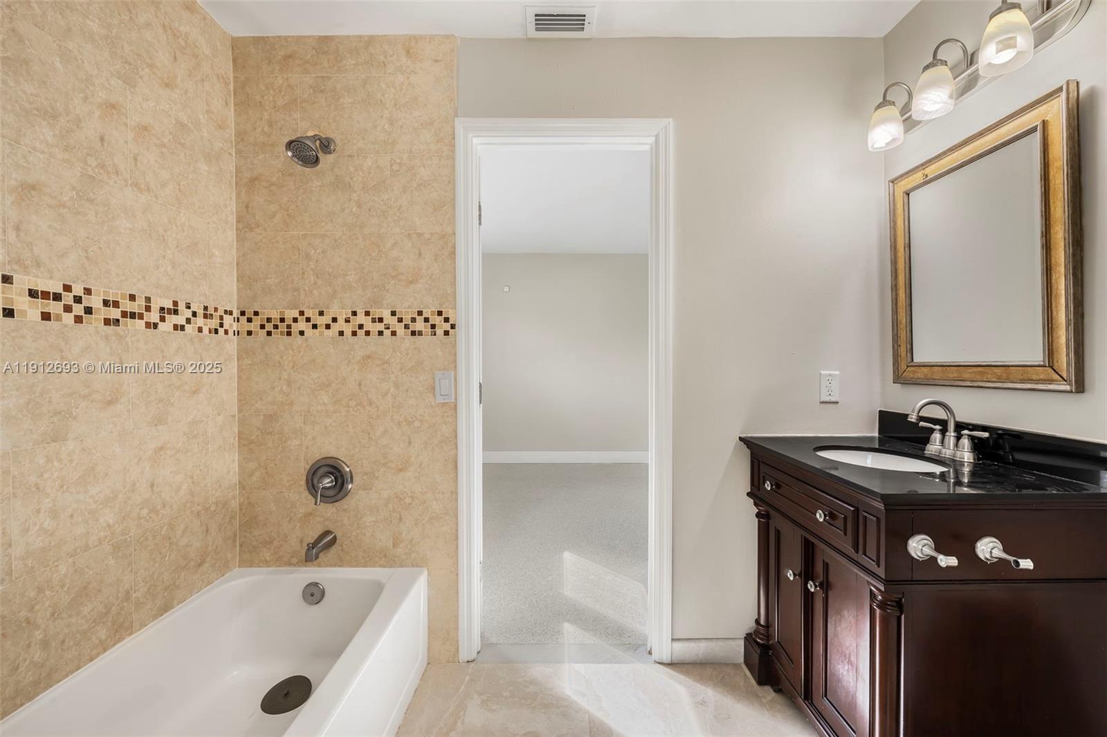 633 Solar Isle Drive Fort Lauderdale, FL 33301 - Photo 13 of 57 a bathroom with a tub sink and mirror