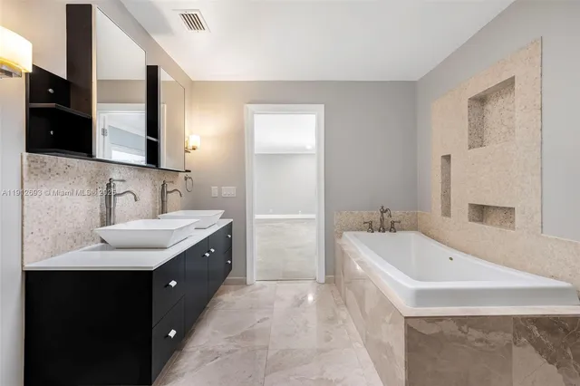 a spacious bathroom with a bathtub sink and mirror