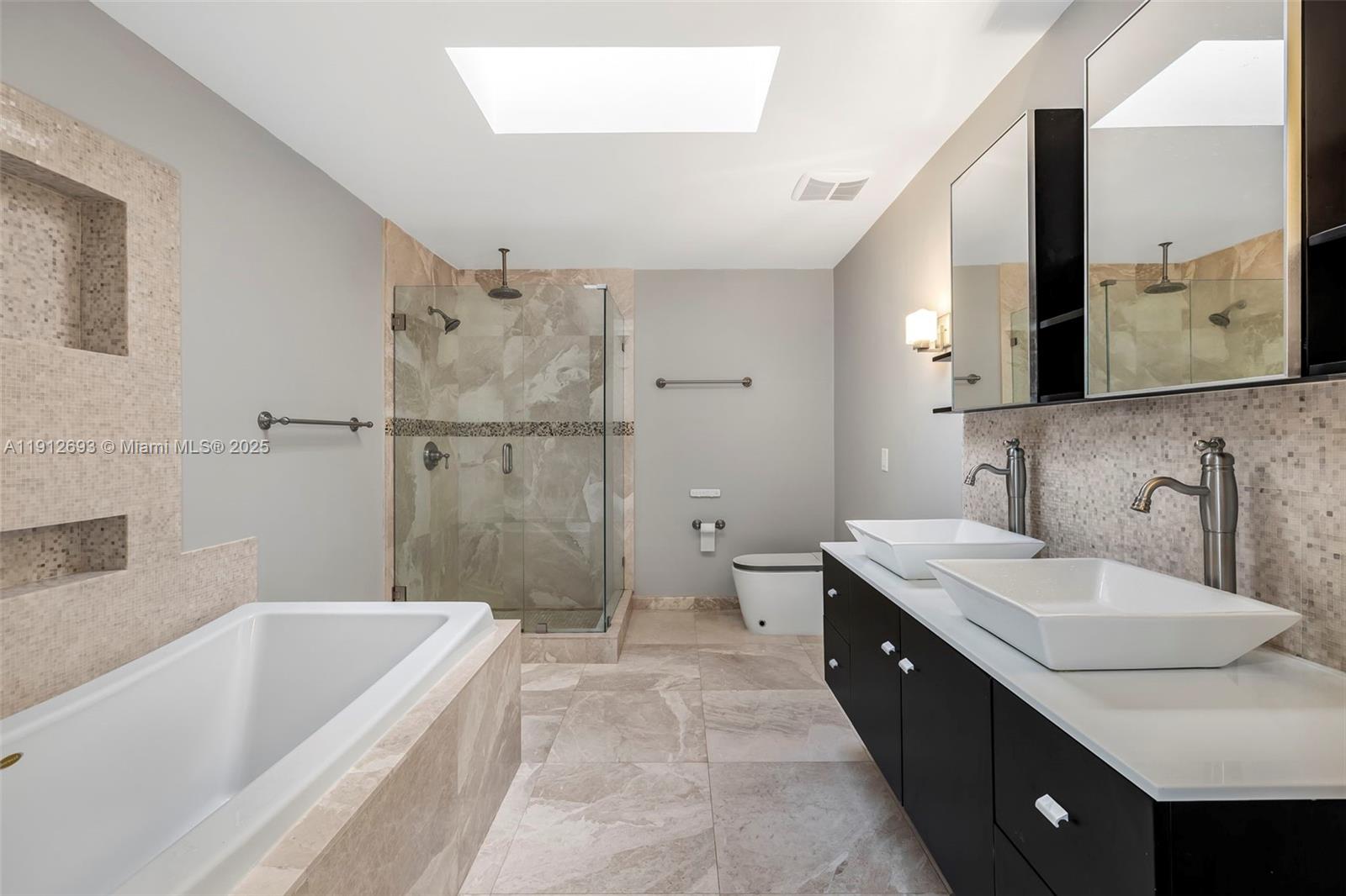 633 Solar Isle Drive Fort Lauderdale, FL 33301 - Photo 33 of 57 a spacious bathroom with a double vanity sink toilet mirror and bathtub