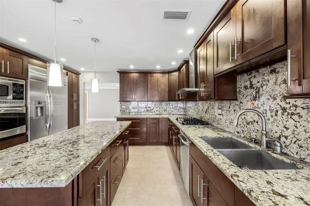 an empty room with kitchen view and windows