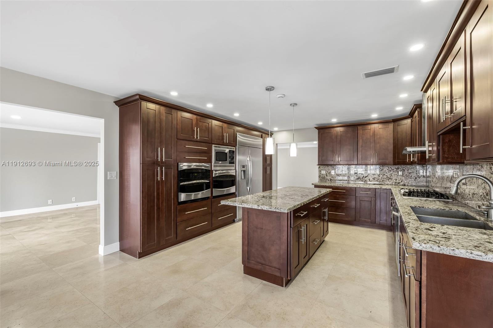 633 Solar Isle Drive Fort Lauderdale, FL 33301 - Photo 48 of 57 a kitchen with stainless steel appliances granite countertop a sink stove and refrigerator