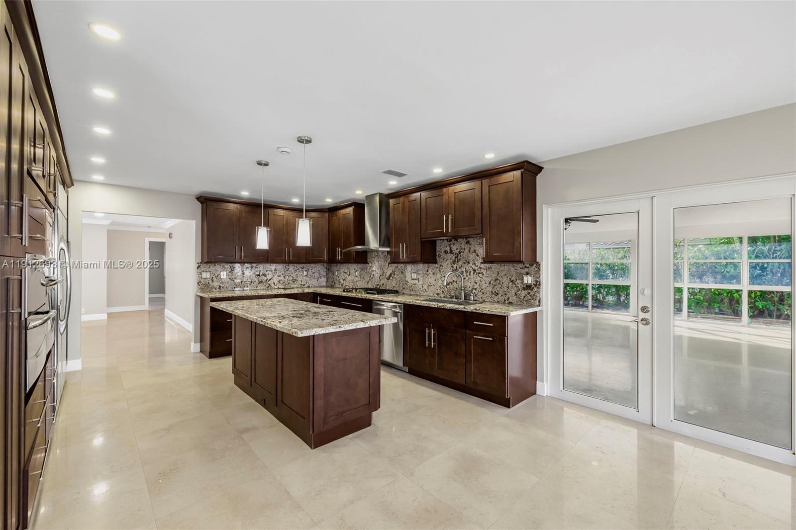 633 Solar Isle Drive Fort Lauderdale, FL 33301 - Photo 5 of 57 a large kitchen with stainless steel appliances granite countertop a stove a sink and a refrigerator