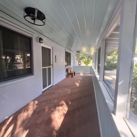 a view of hallway with furniture and a ceiling fan