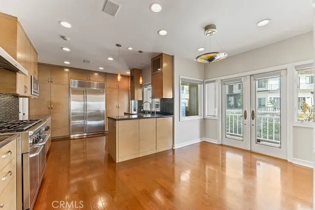 a view of a kitchen with refrigerator and wooden floor