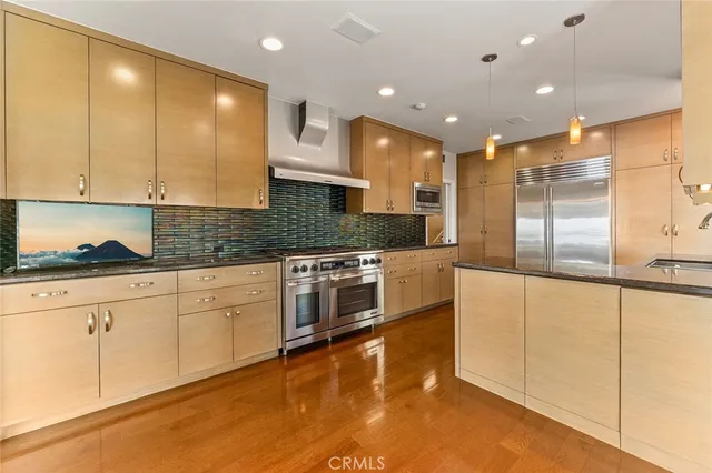 a large kitchen with stainless steel appliances granite countertop a stove a sink and white cabinets