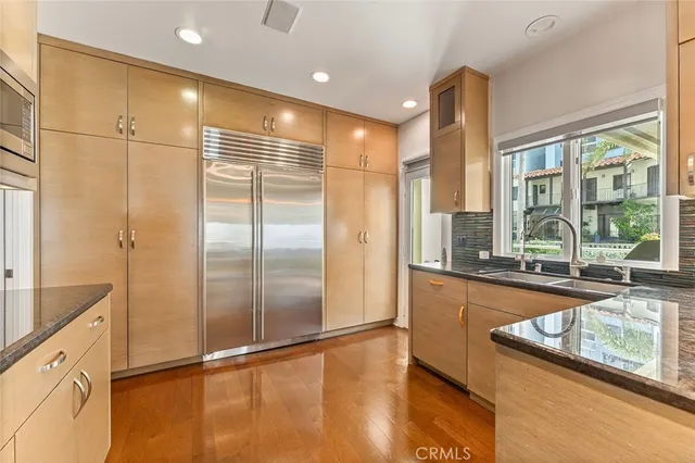 a large kitchen with kitchen island a large window appliances and cabinets