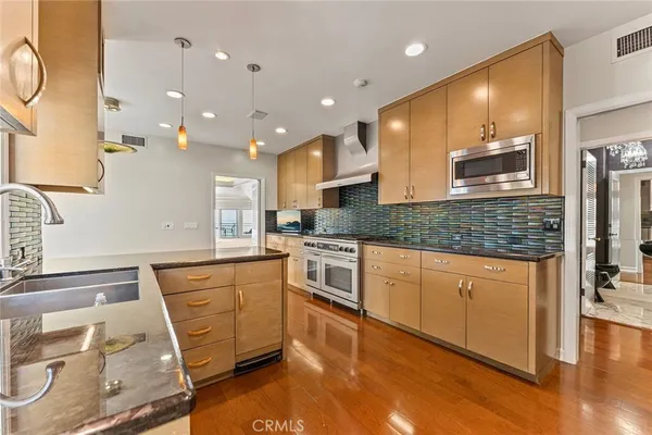 a large kitchen with stainless steel appliances granite countertop a sink and a stove