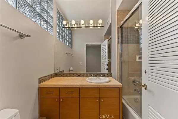 a bathroom with a sink mirror and a shower