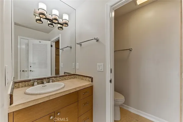 a bathroom with a sink and mirror with toilet