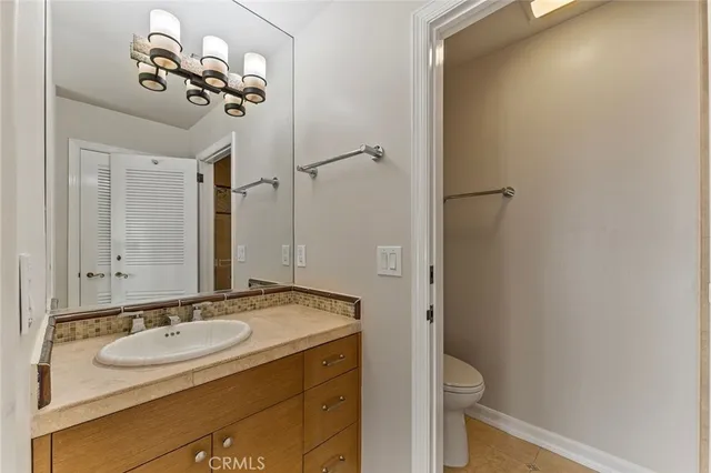 a bathroom with a sink and mirror with toilet