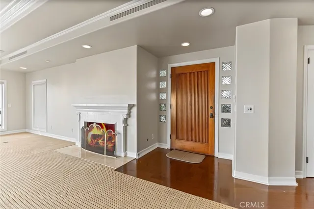 a view of a hallway with wooden floor and a refrigerator