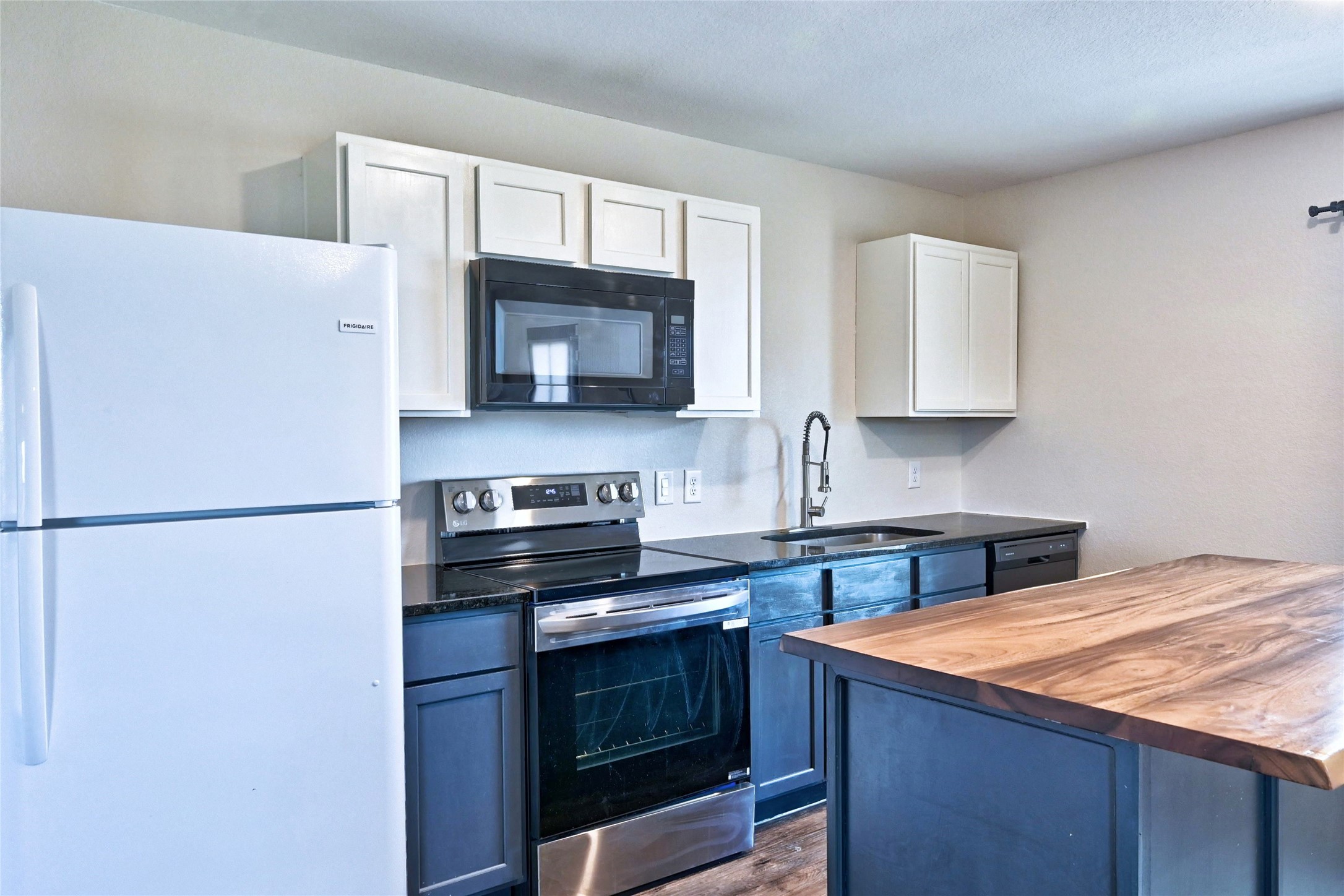 16623 Colleen Place Conroe, TX 77306 - Photo 12 of 44 a kitchen with stainless steel appliances a stove microwave and sink