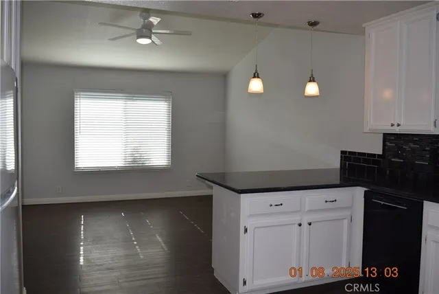a room with a window and a chandelier fan